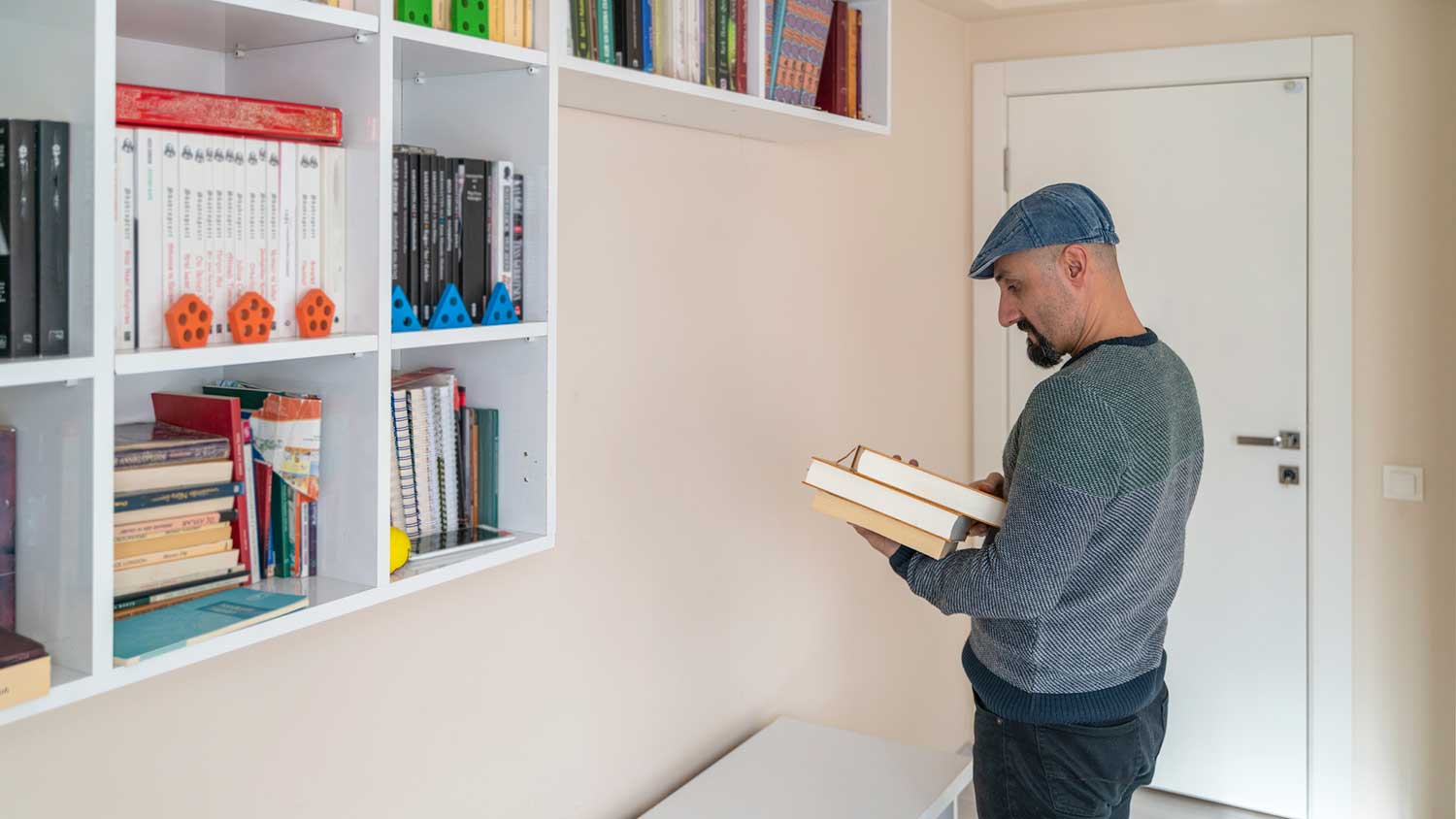 Man arranging books on a bookshelf