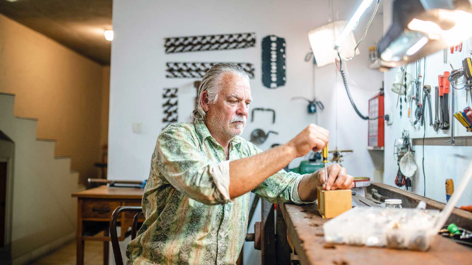 A man working at his home workspace with fluorescent lights