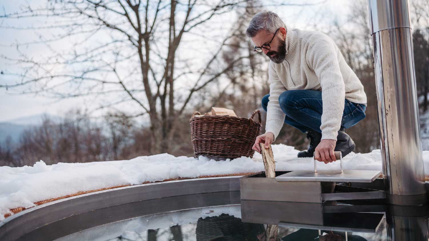 A man firing up the stove of the hot tub