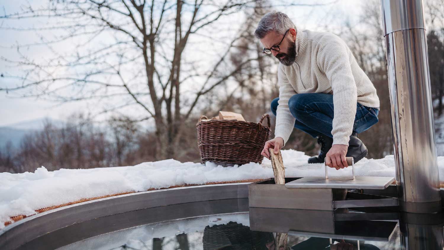 A man firing up the stove of the hot tub