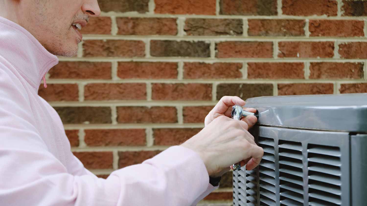 A man inspecting an AC unit