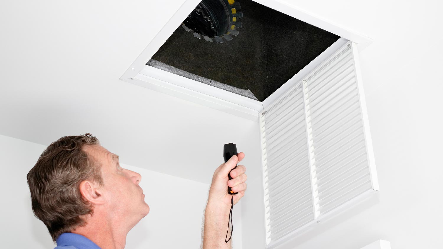 A man inspecting the air ducts