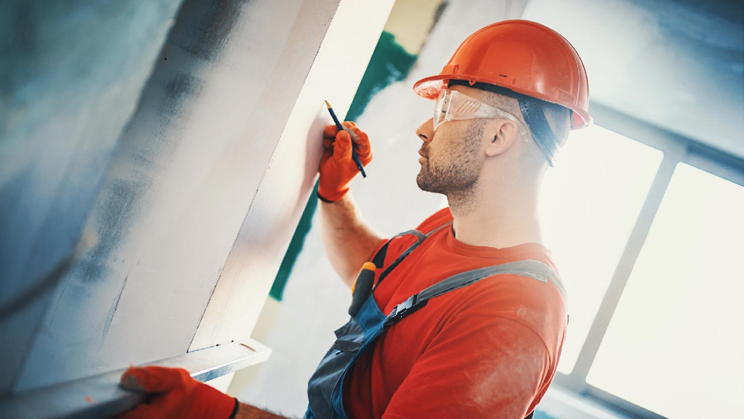 A man inspecting a drywall