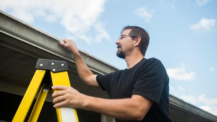 A man inspecting gutters