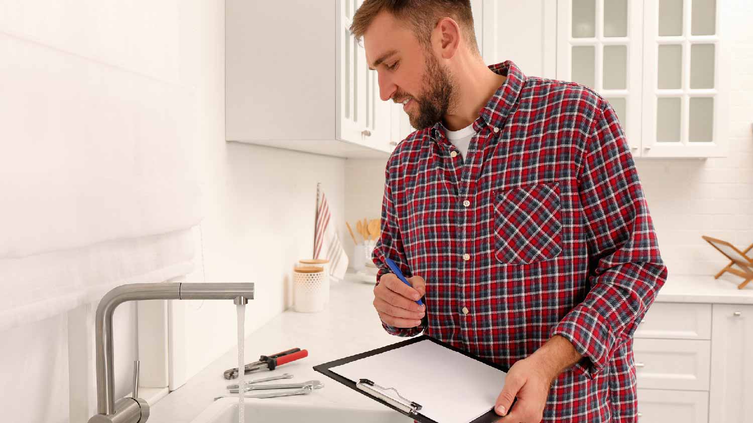 A man inspecting a kitchen faucet