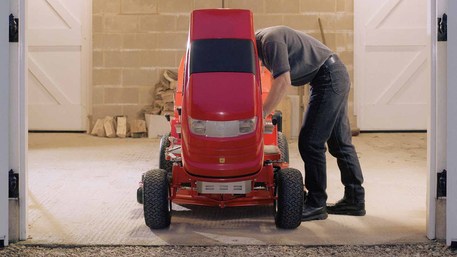 A man inspecting a lawn mower