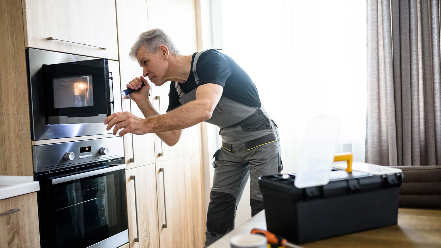 A man inspecting a microwave