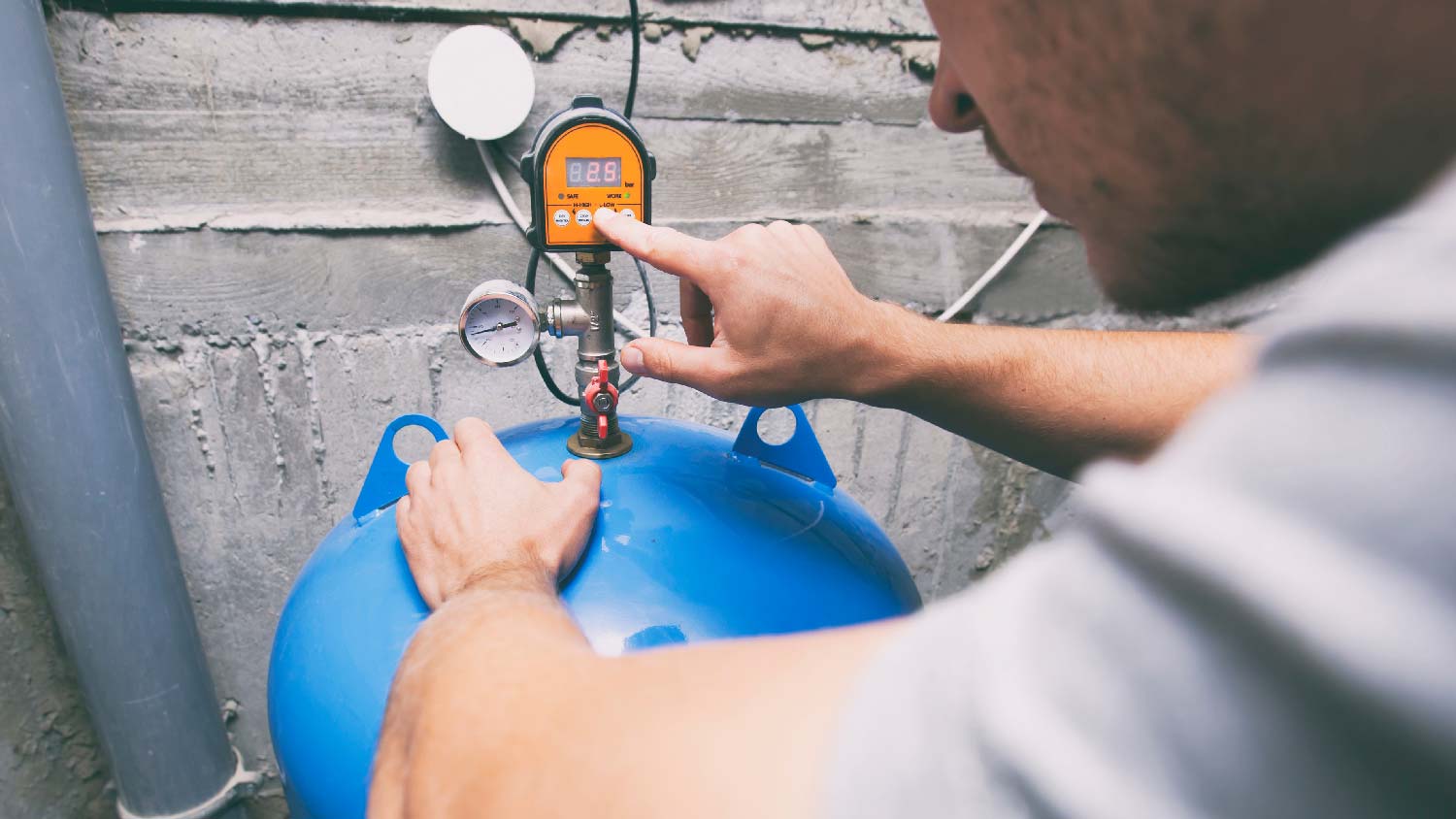 A man inspecting a pressure tank