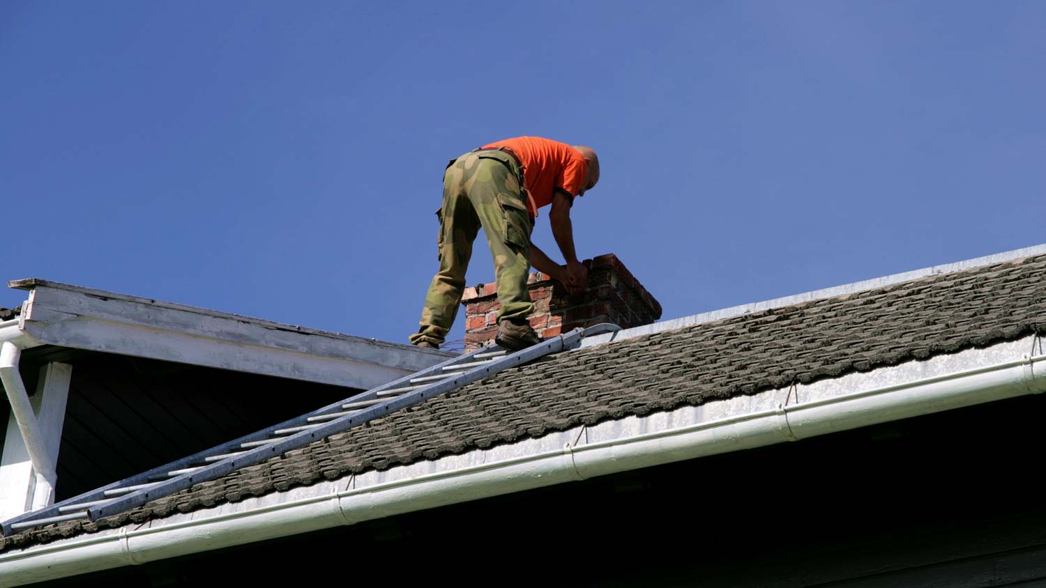 A man inspecting a roof