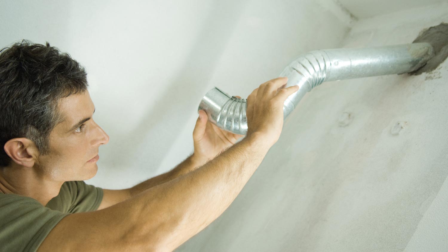 A man installing an air duct