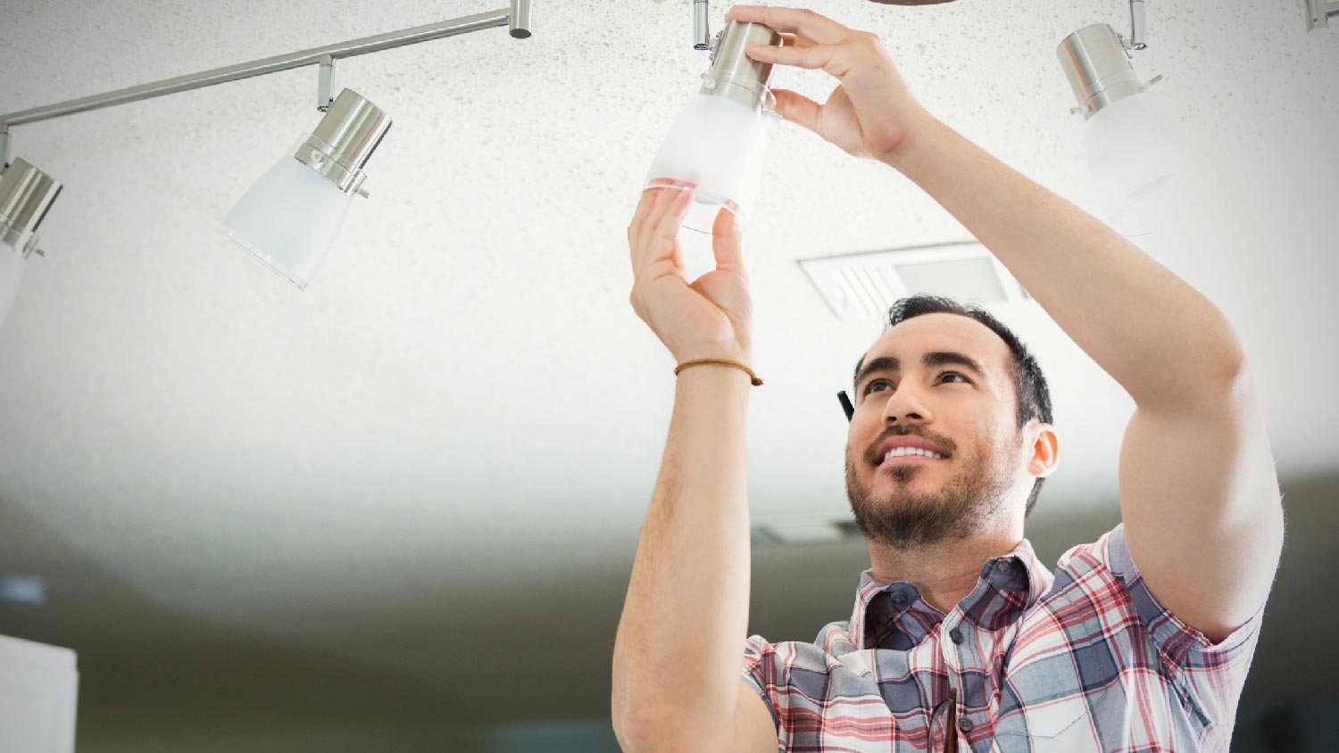 A man installing new bulbs to track lights