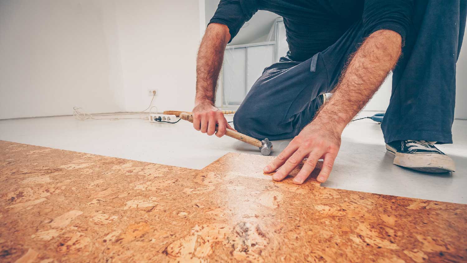 A man installing cork flooring