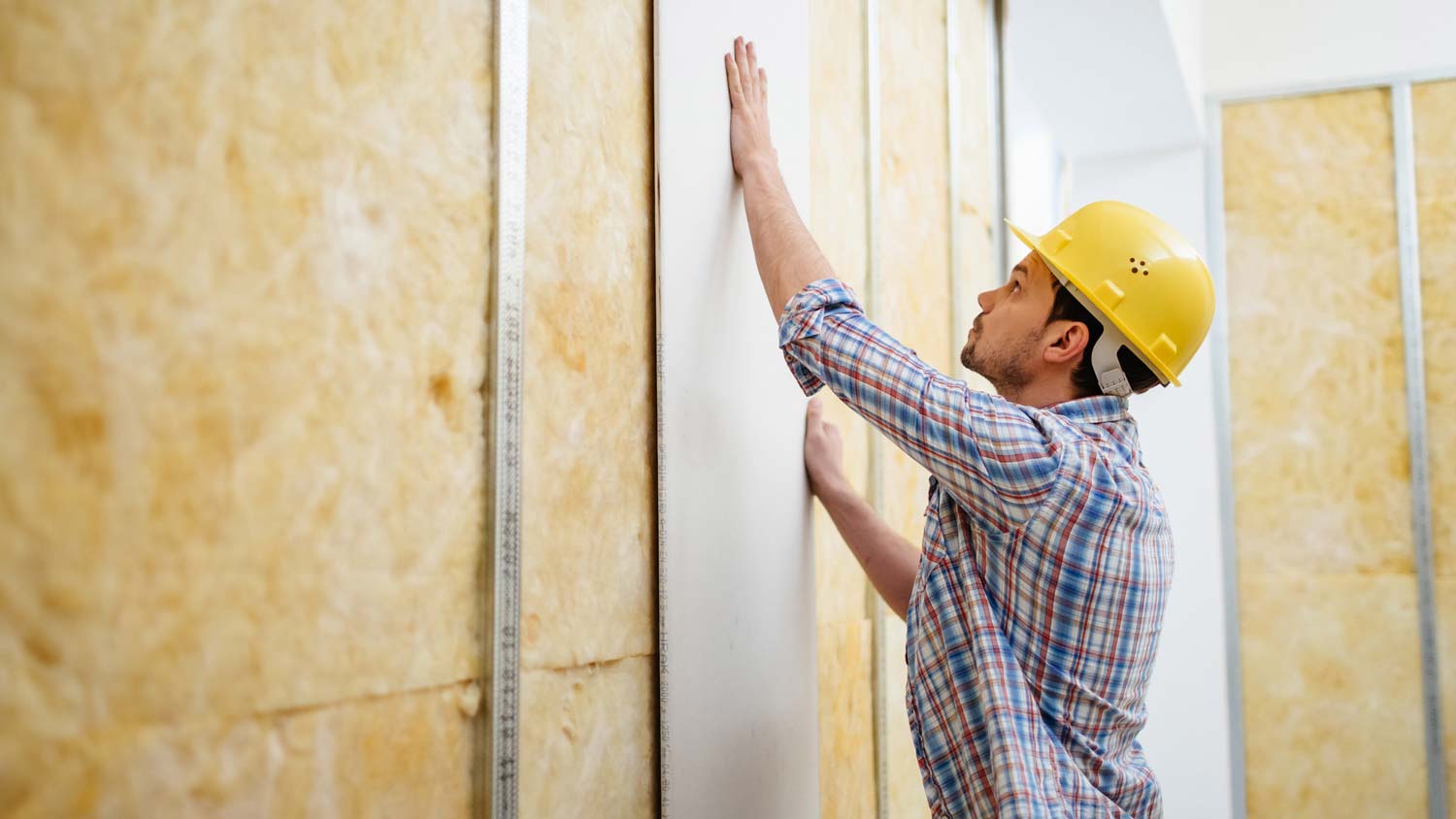 A man installing drywall