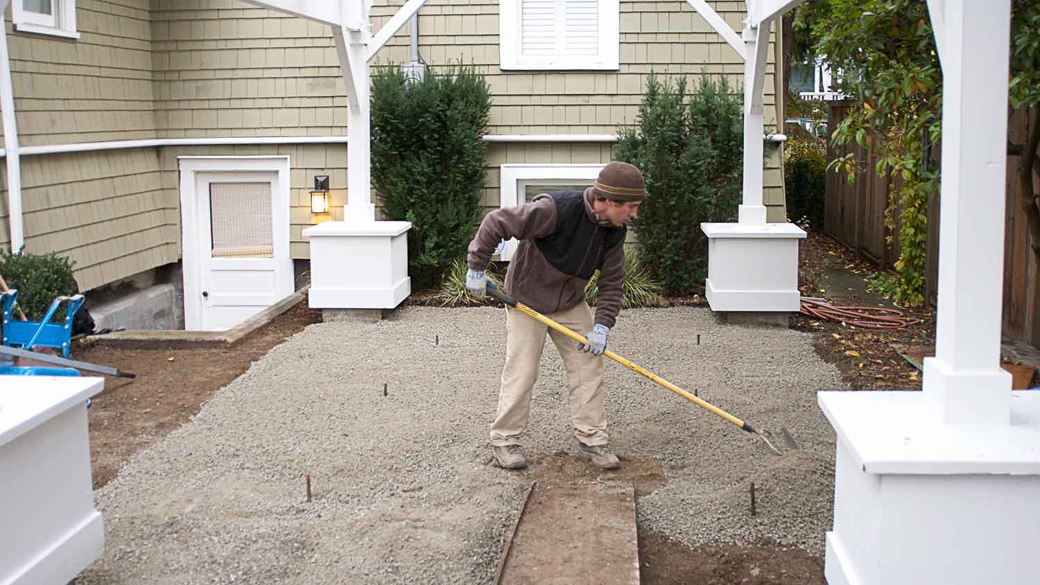 Man installing gravel for backyard landscaping