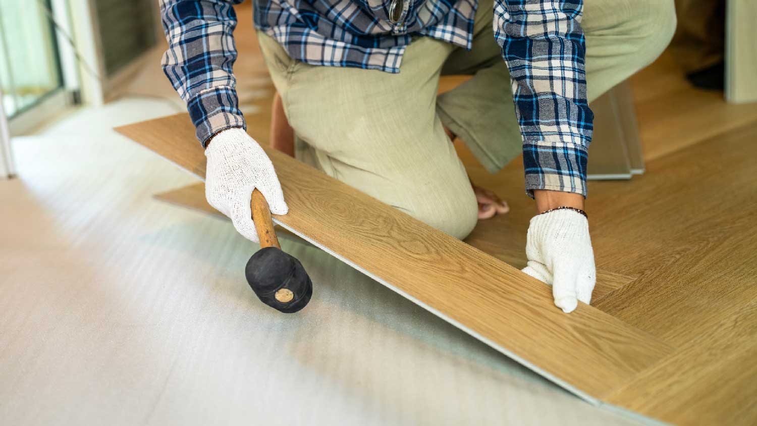 A man installing laminate flooring