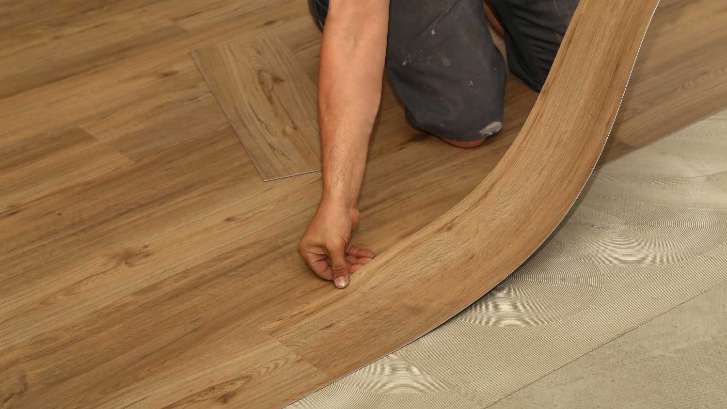 A man installing luxury vinyl planks