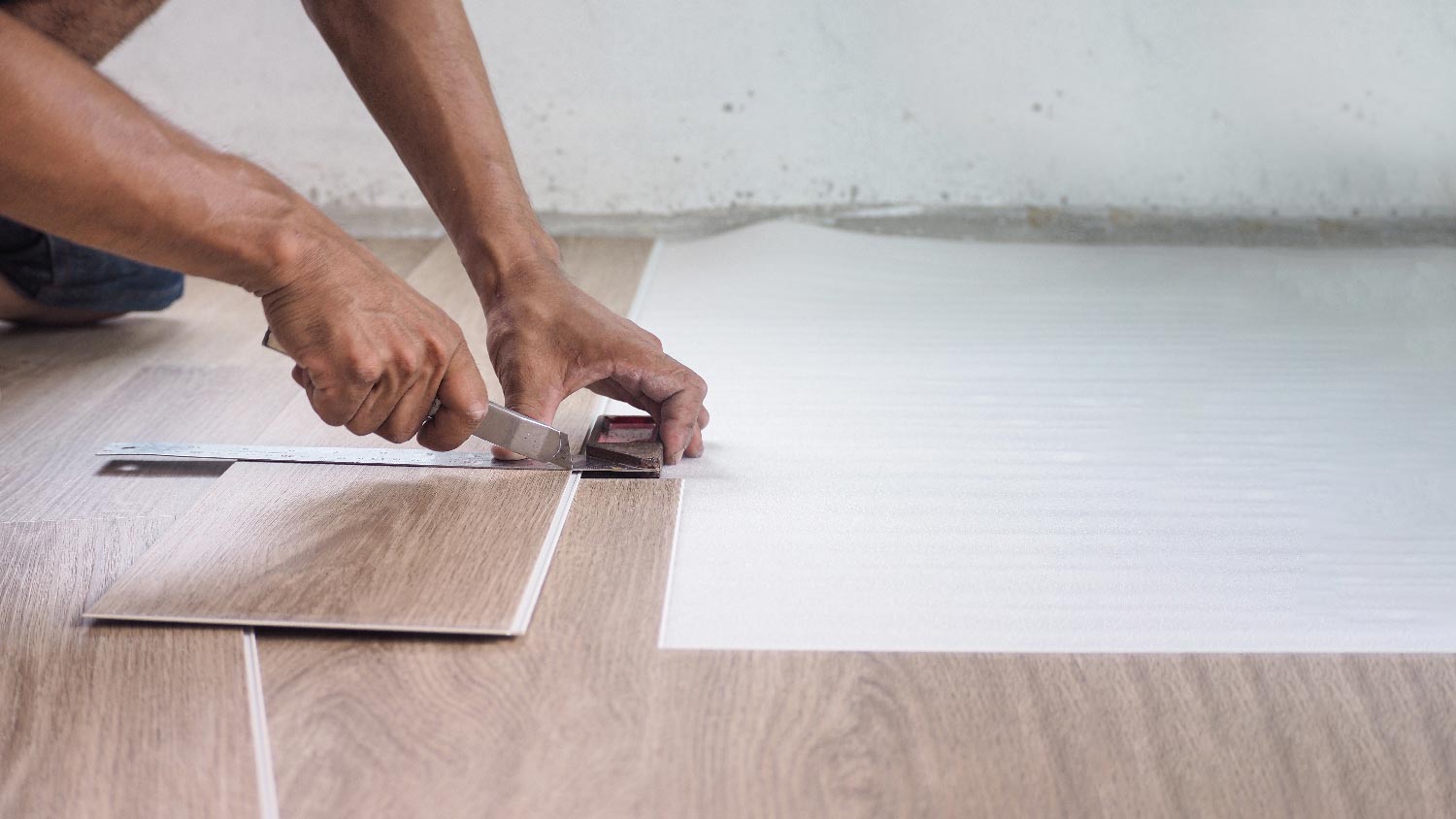 A man installing luxury vinyl tiles