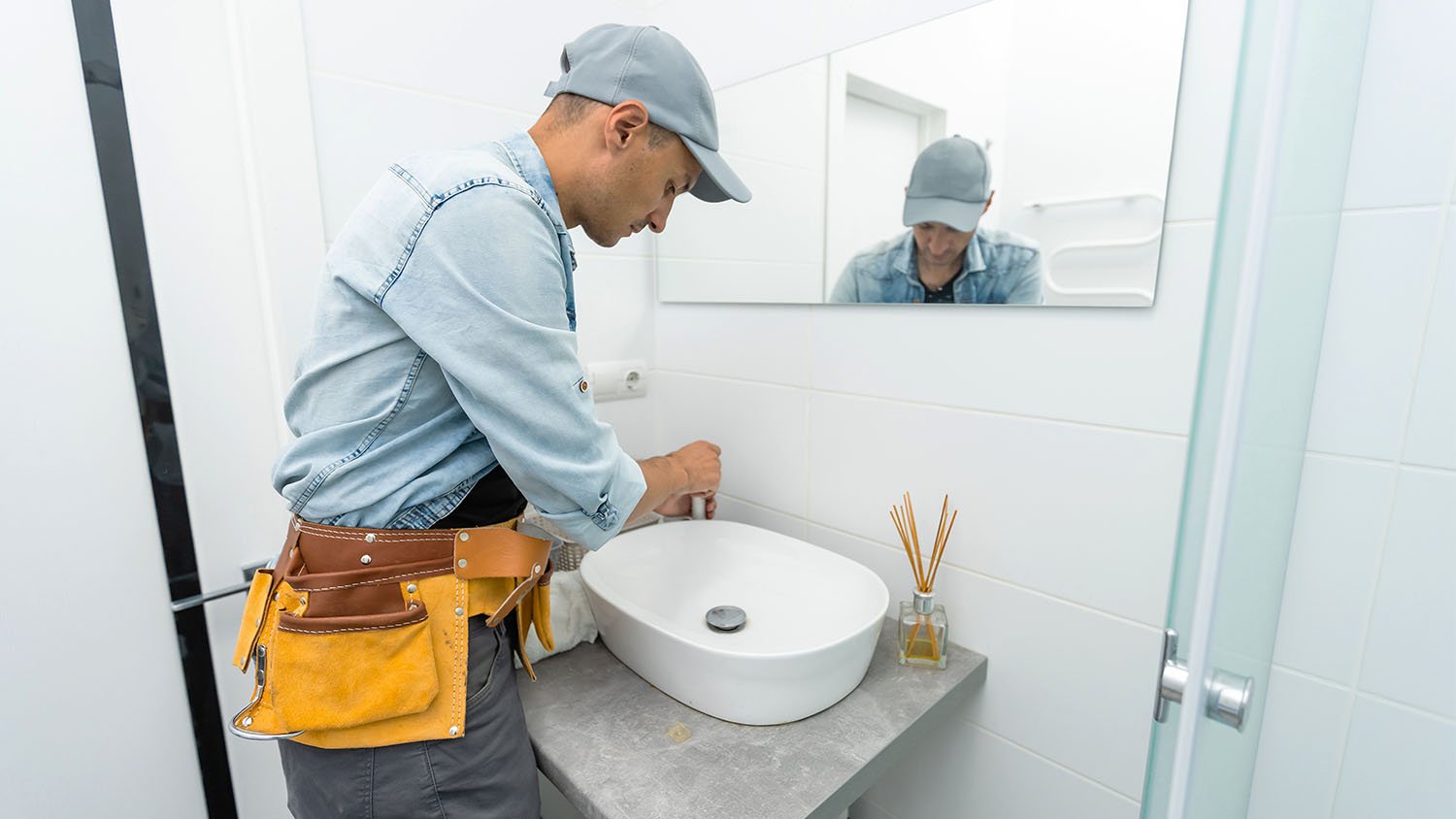 man installing new sink in bathroom 