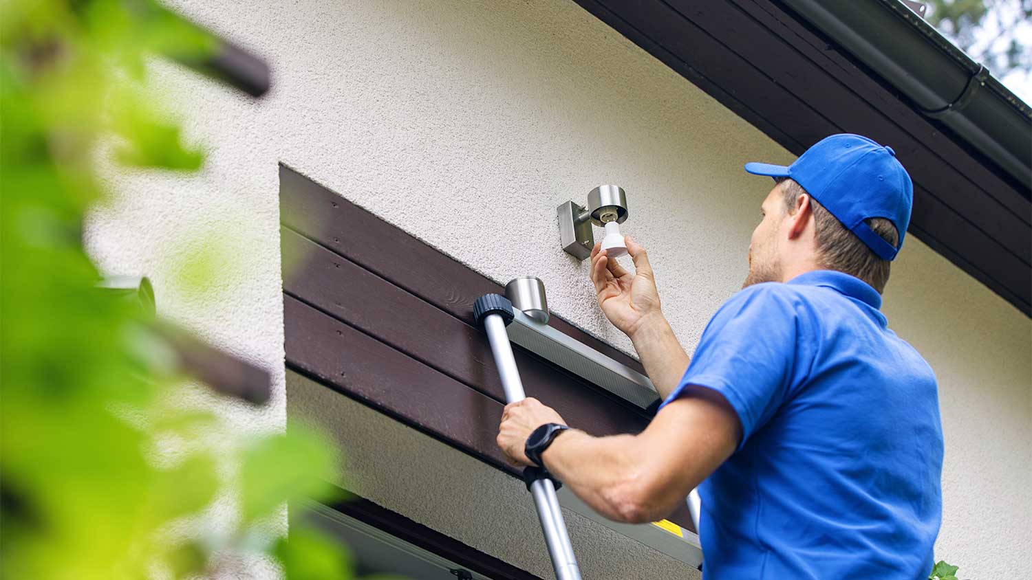 A man installs an outdoor light