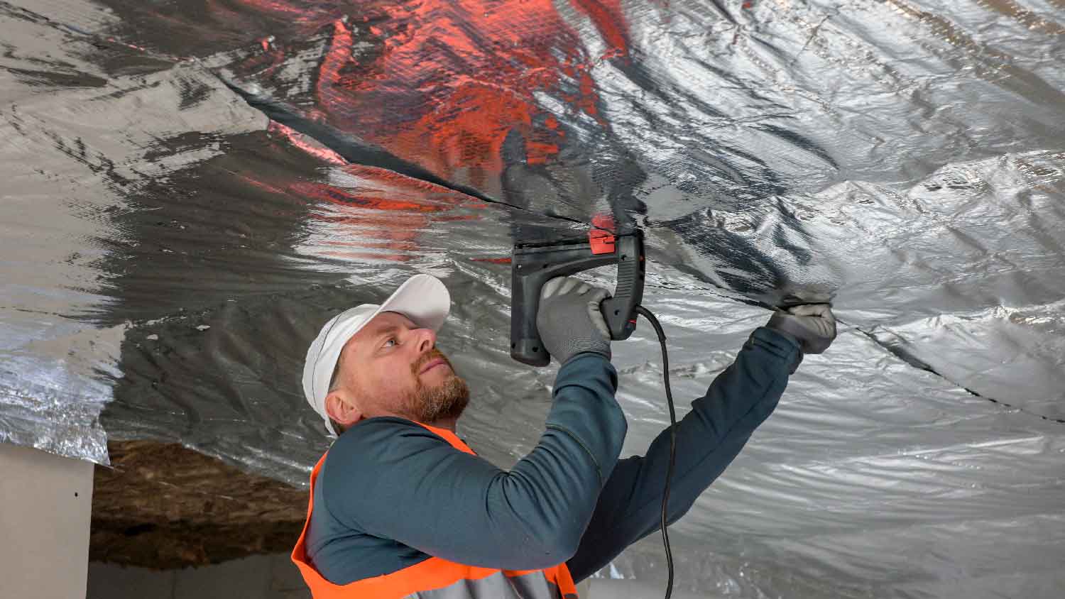 A man installing a radiant barrier