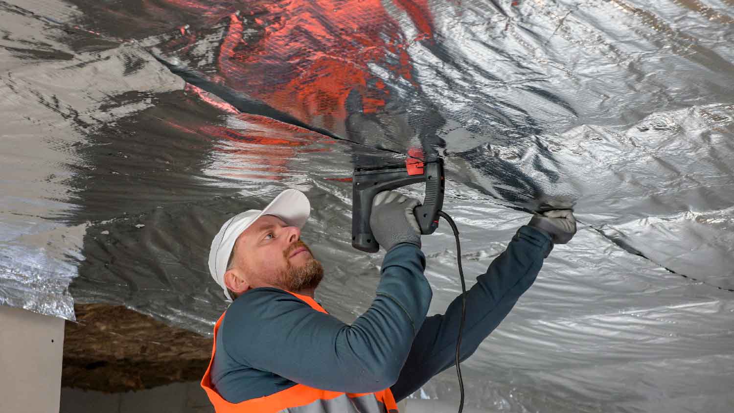 A man installing a radiant barrier 