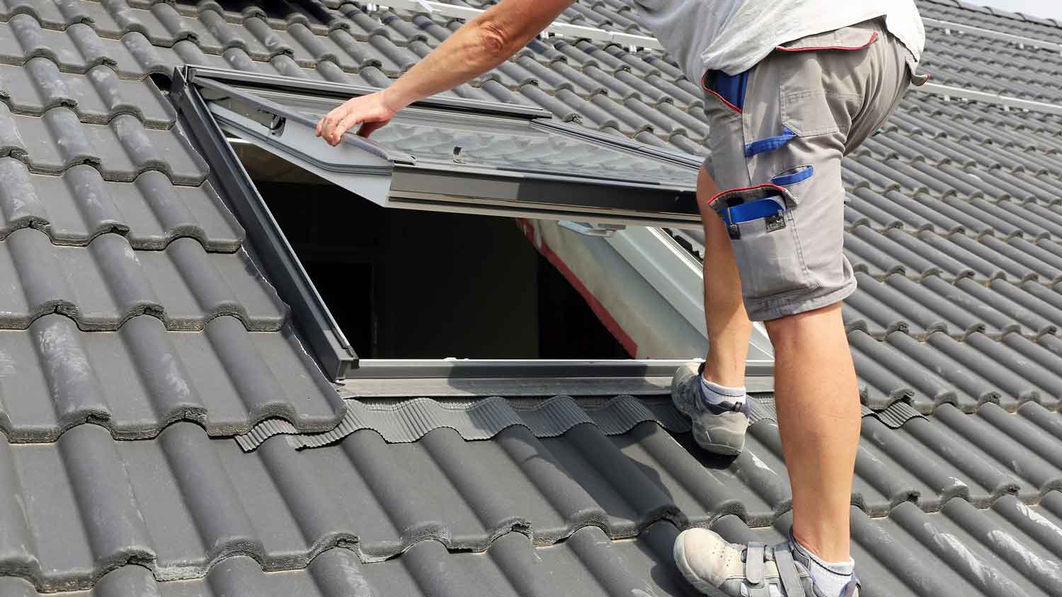 A man installing a skylight