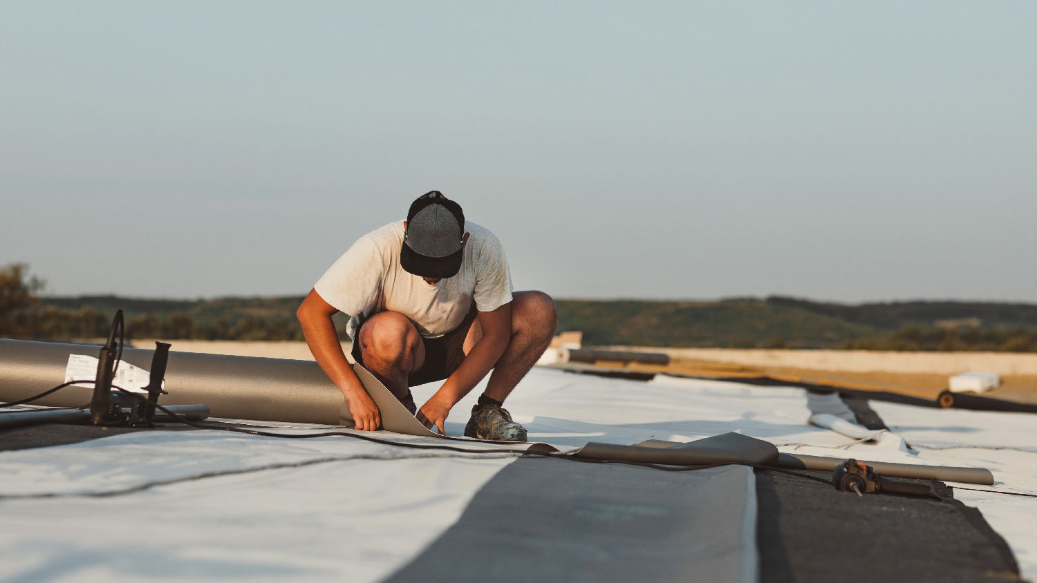 A man installing TPO roofing