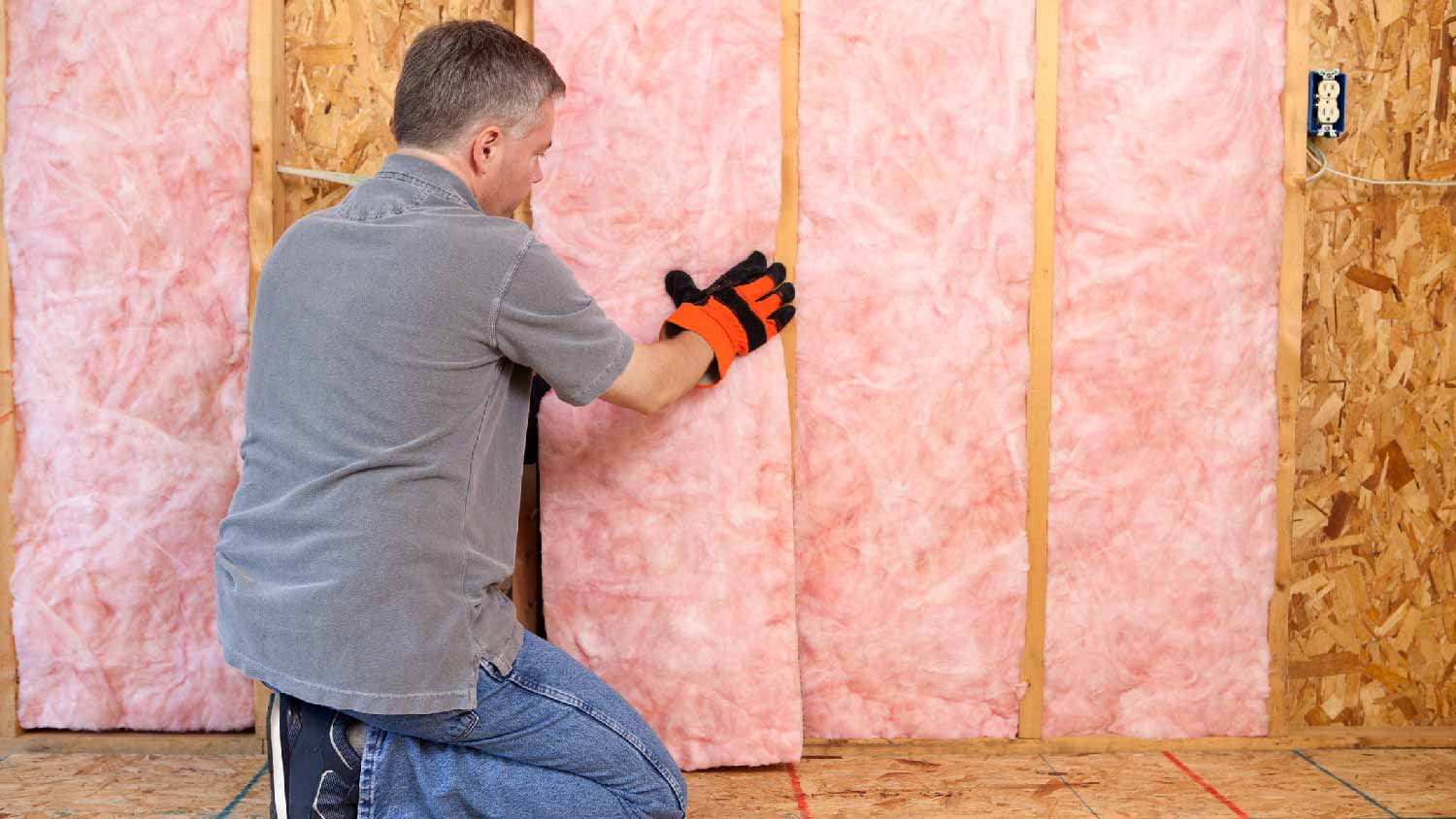 A man installing wall insulation