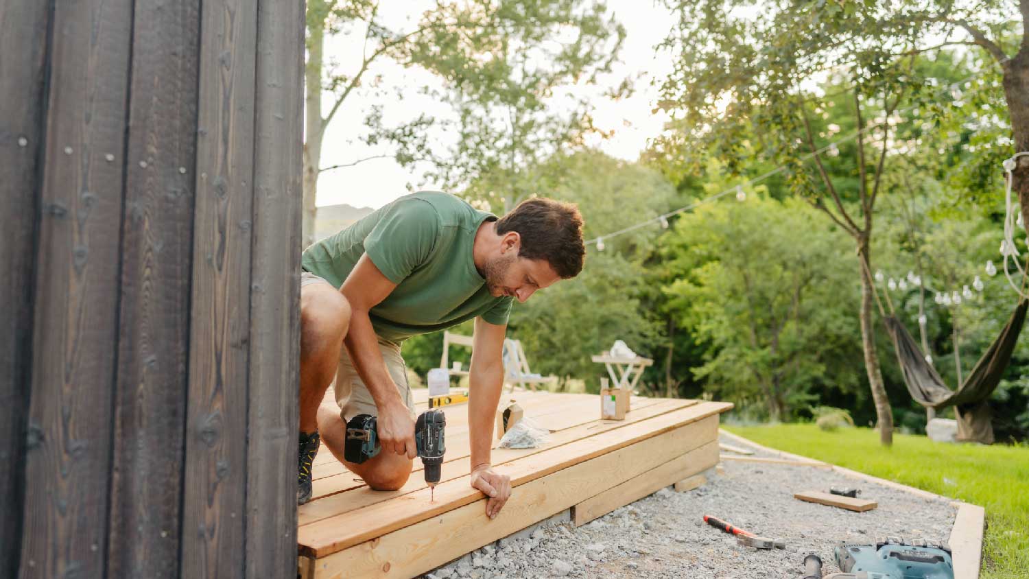 A man installing wooden boards on a deck 