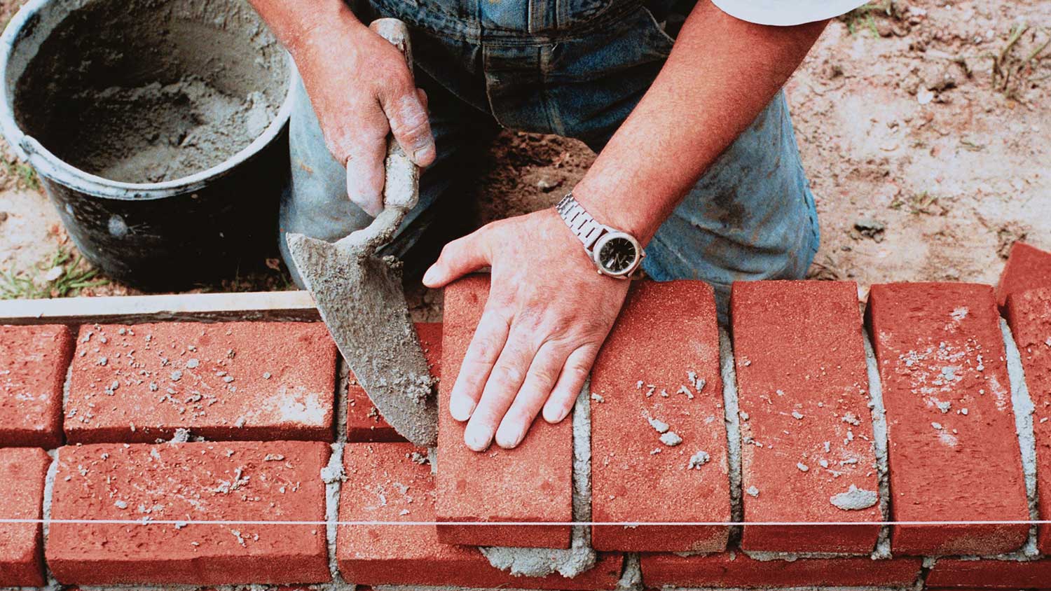 Worker building a redbrick wall