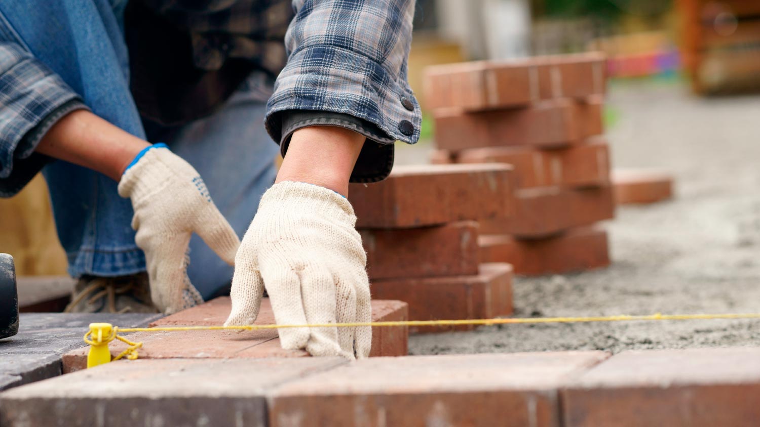 A man laying gray concrete paving slabs