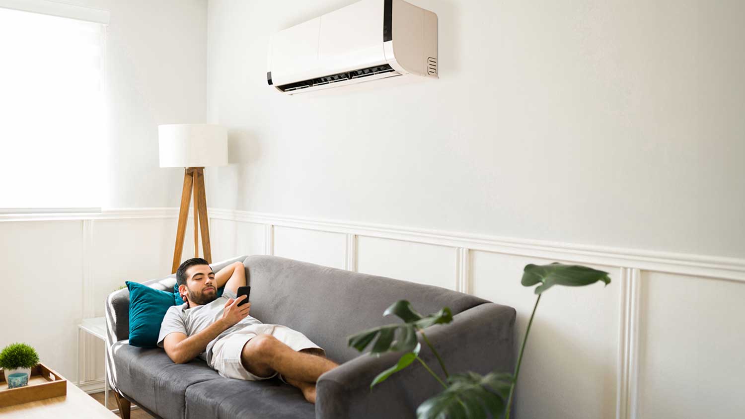 Young man relaxing on the couch and watching his phone