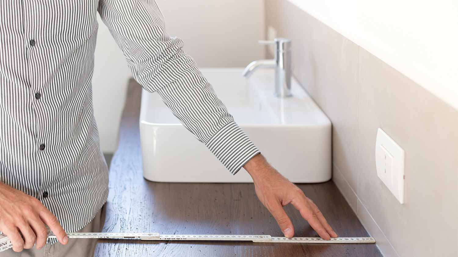 man measuring new bathroom countertop