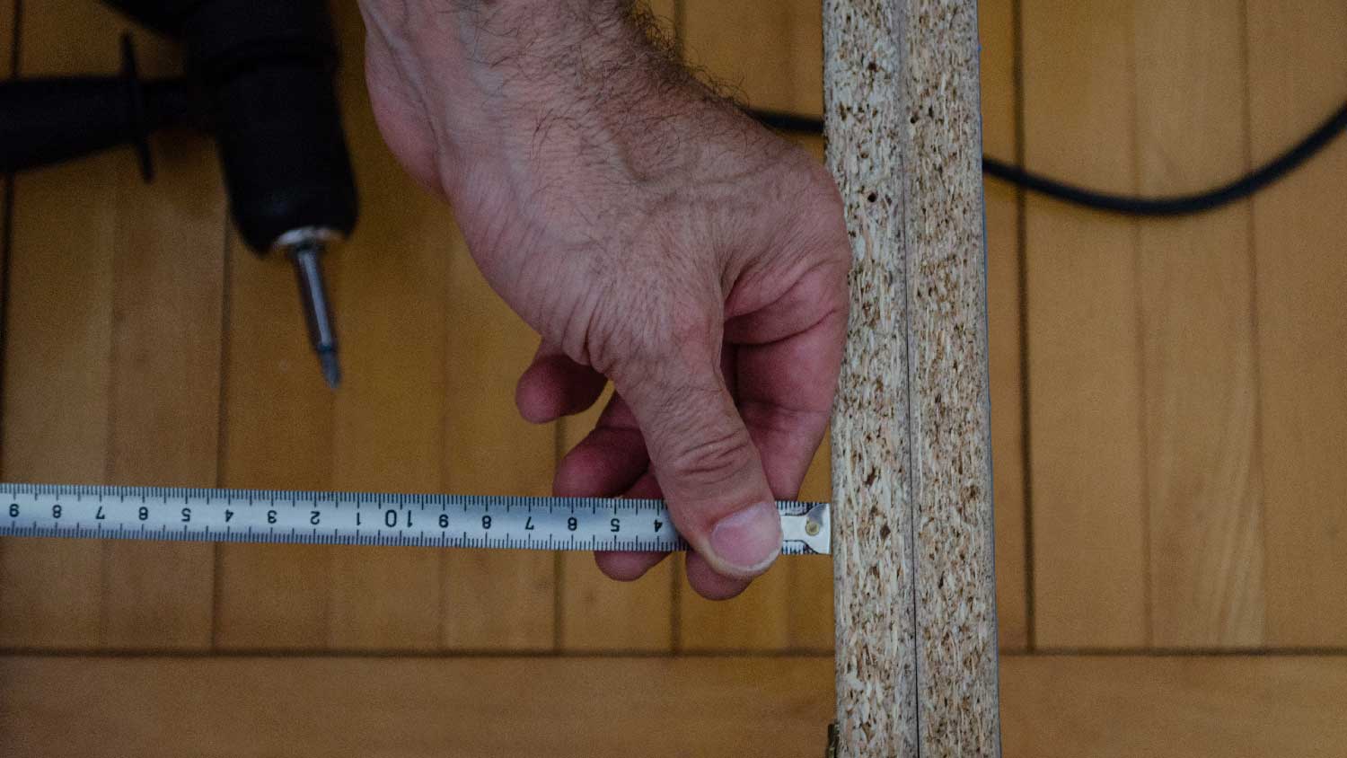 A man measuring a bed frame