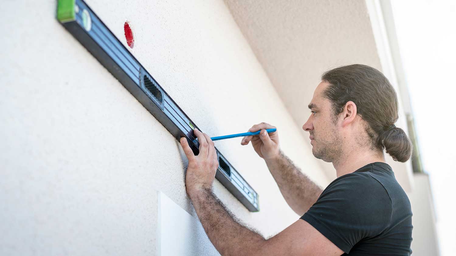 Man using level tool to measure the patio wall