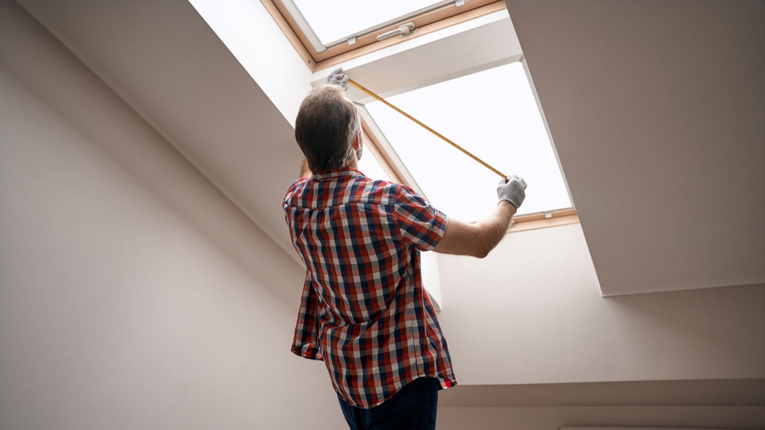 man measuring skylight