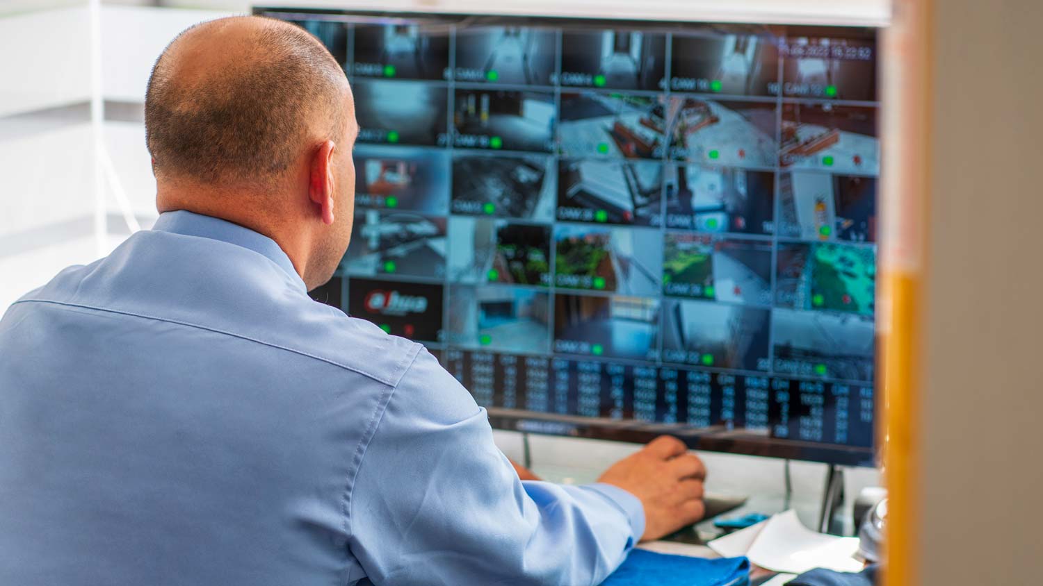 A man monitoring a home’s security cameras