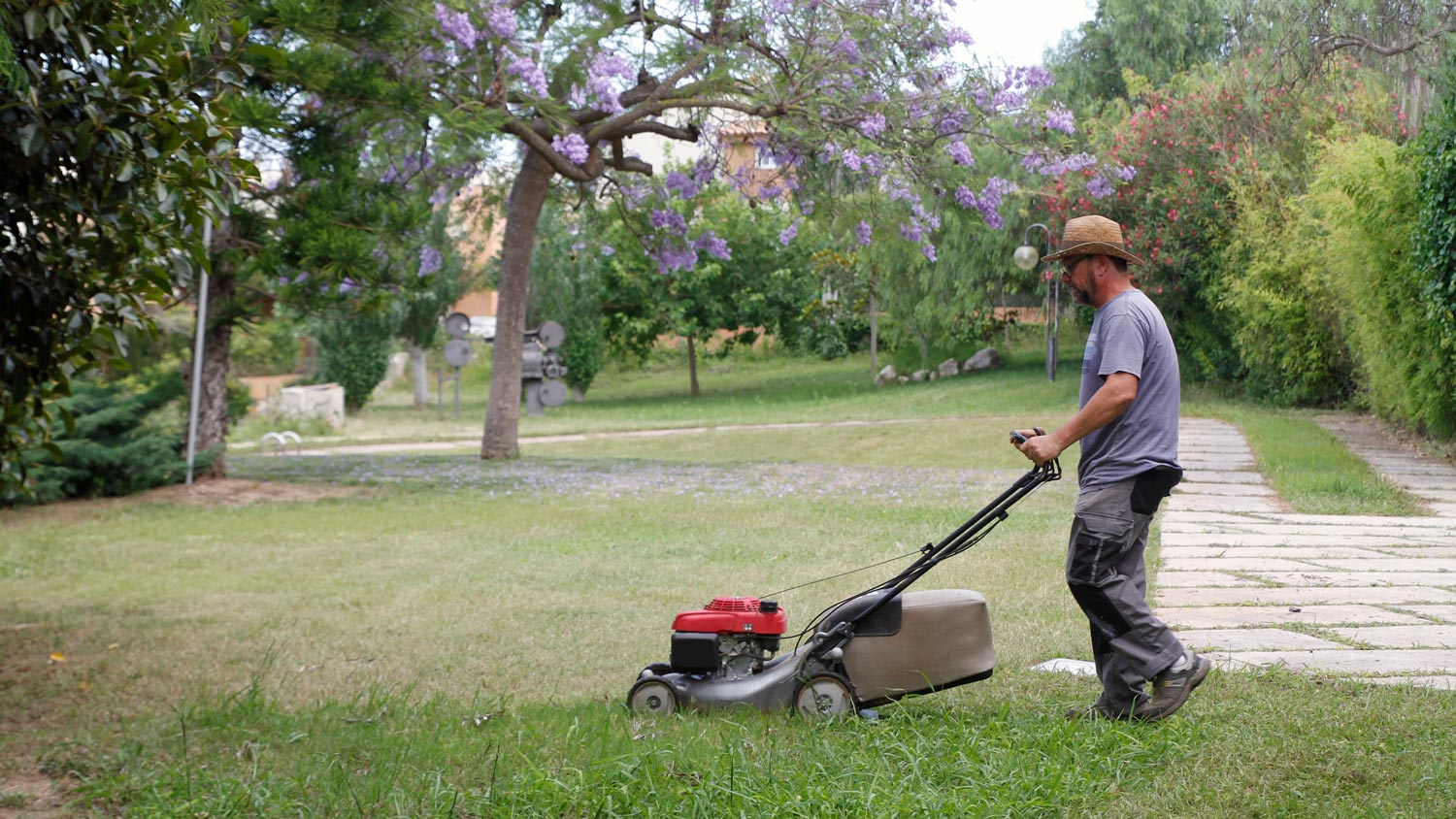 A man mowing the grass with a lawn mower