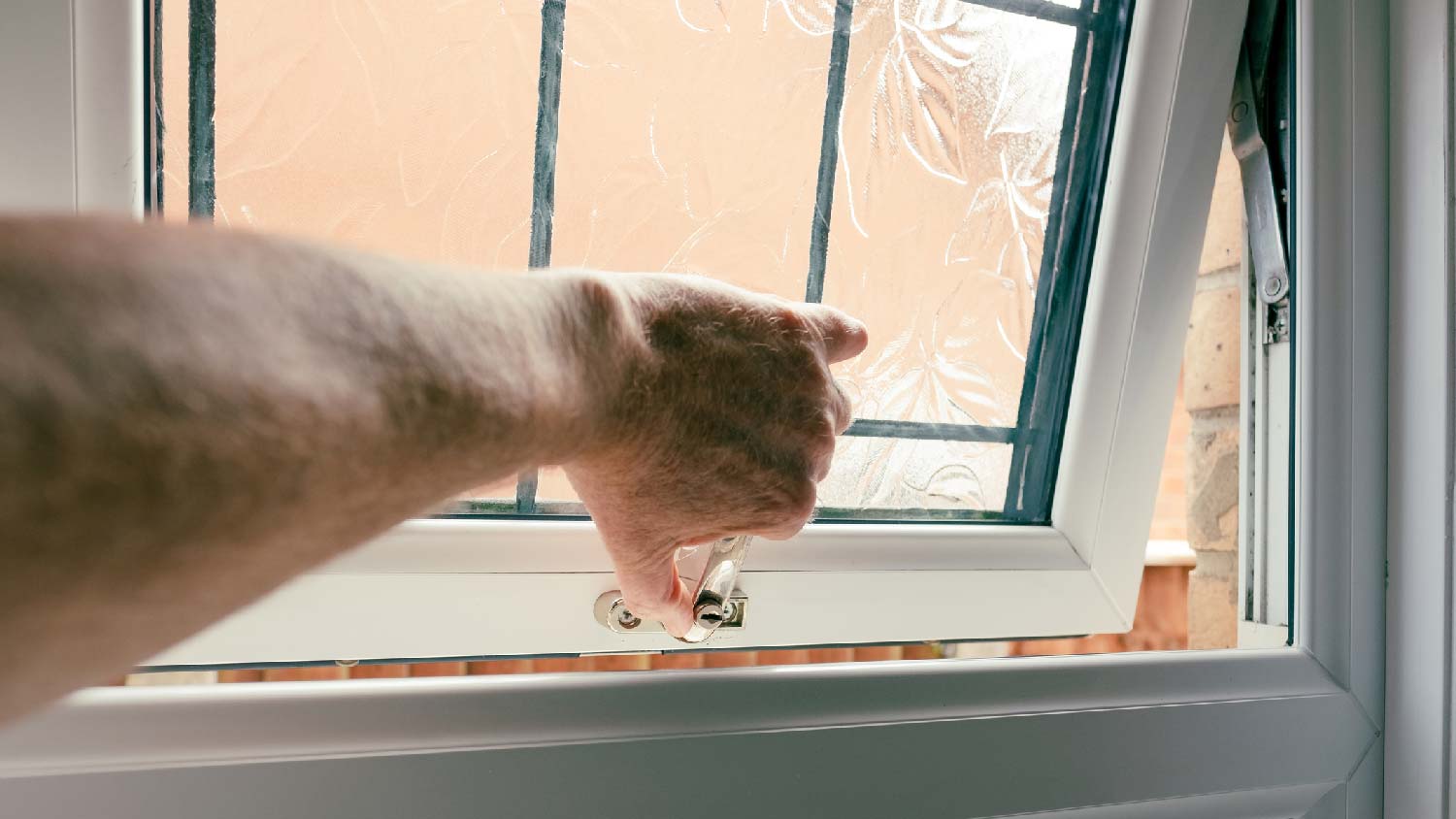 A man opening the bathroom window 