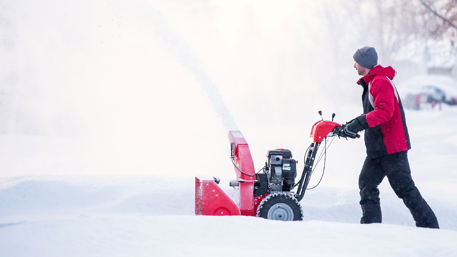 A man operating a snow blower