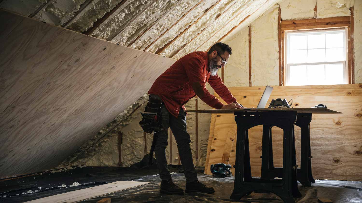 A man organising the attic’s insulation