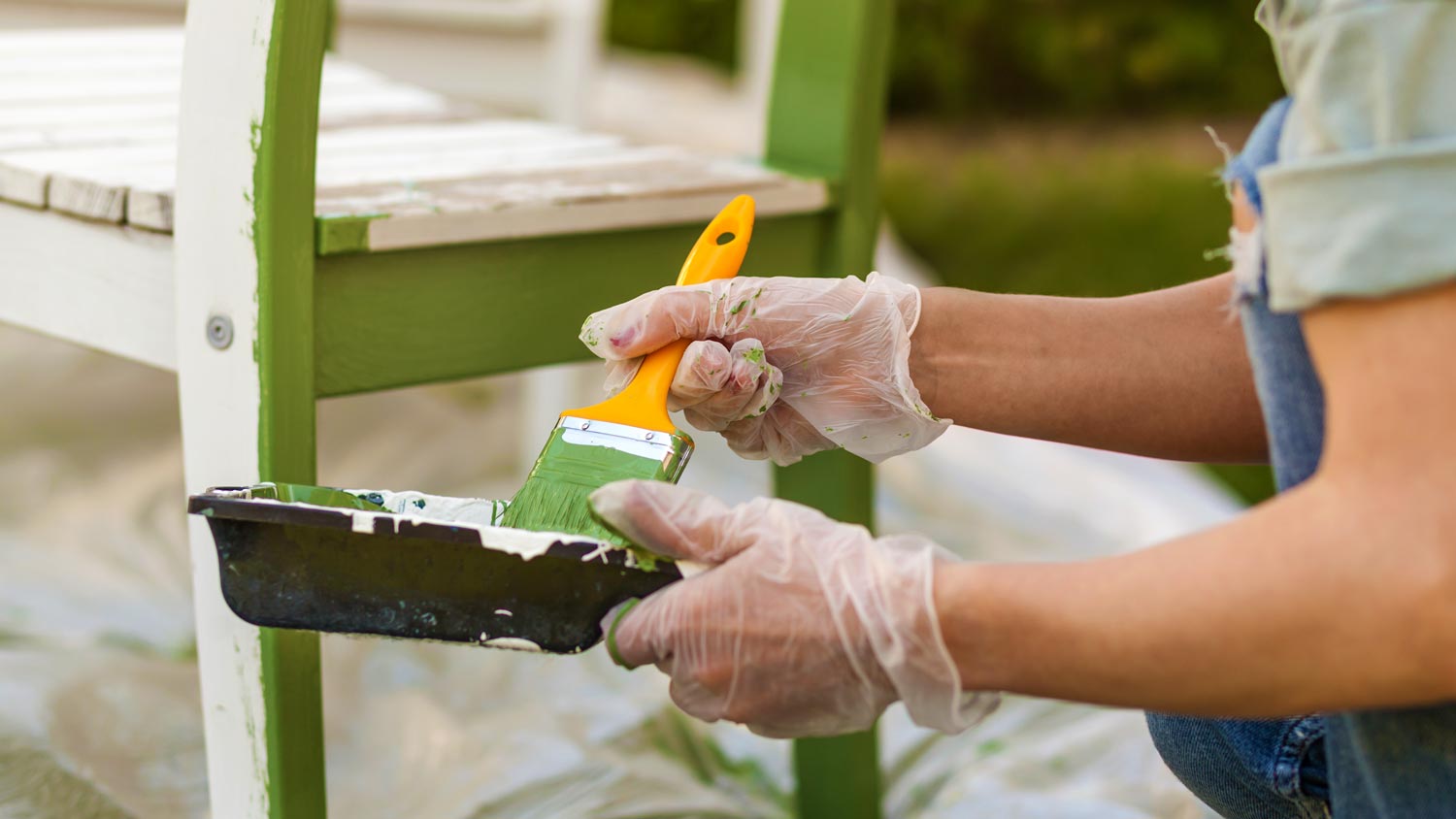 man painting chair green