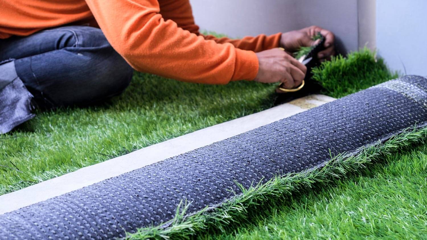 A man placing artificial grass