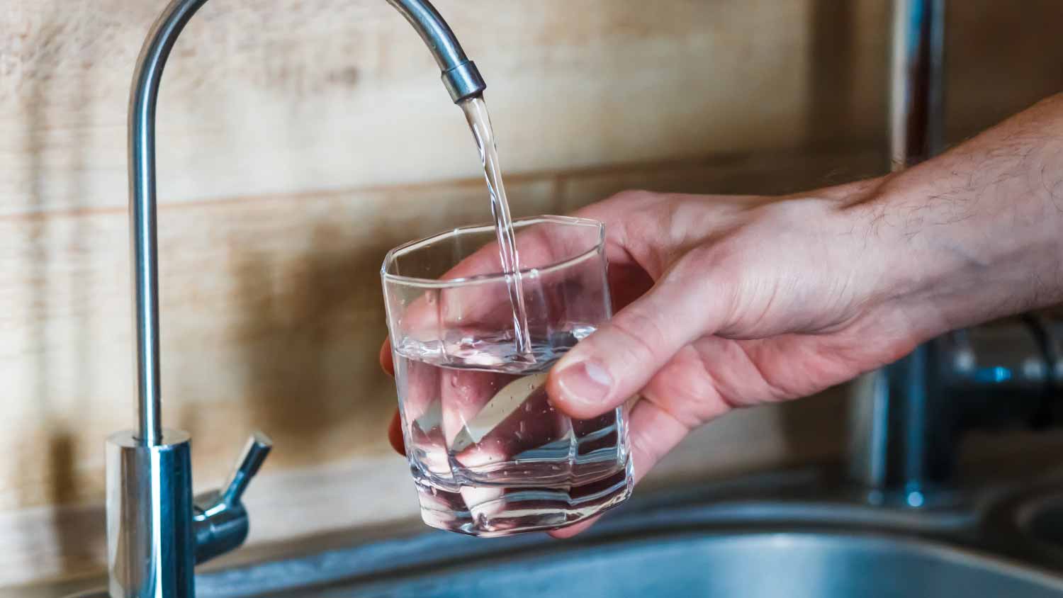 man pouring water from filter tap