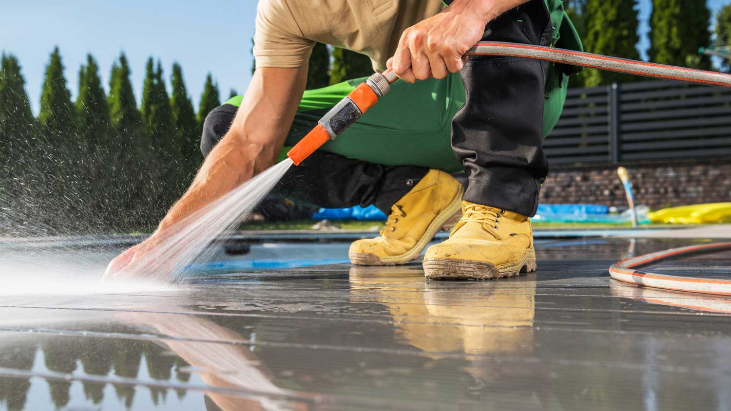 A man power washing a pool deck