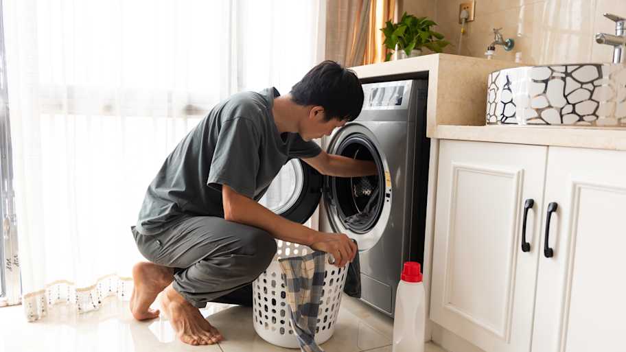 A man putting clothes in the washing machine