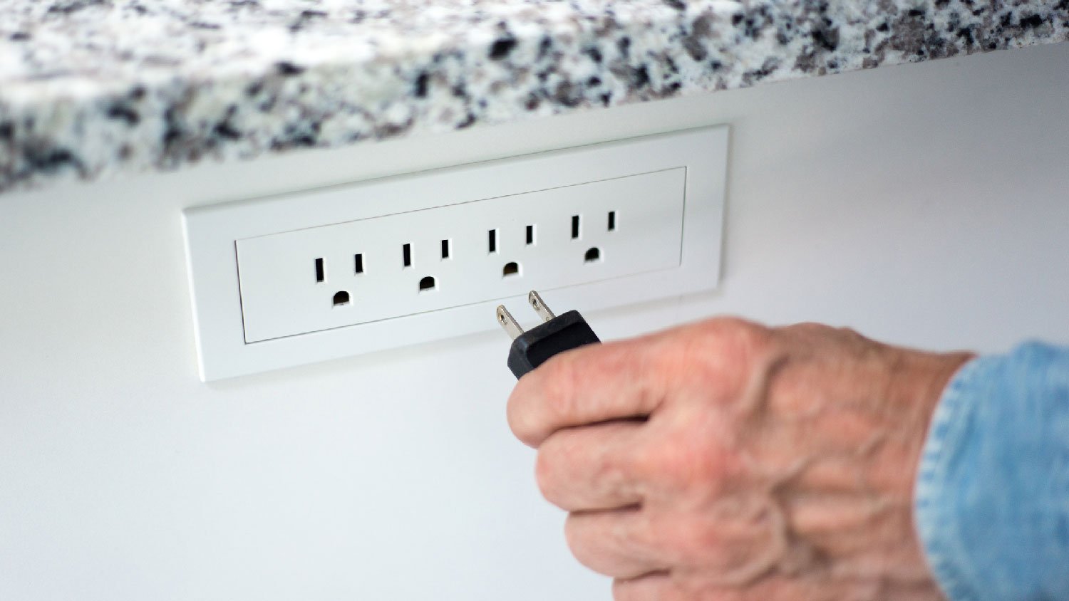 A man putting a plug in an outlet