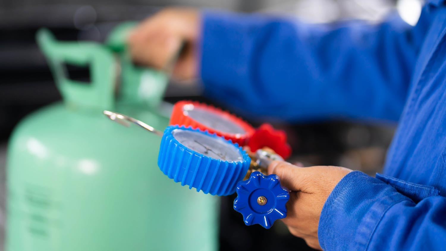 A man recharging an AC with refrigerant