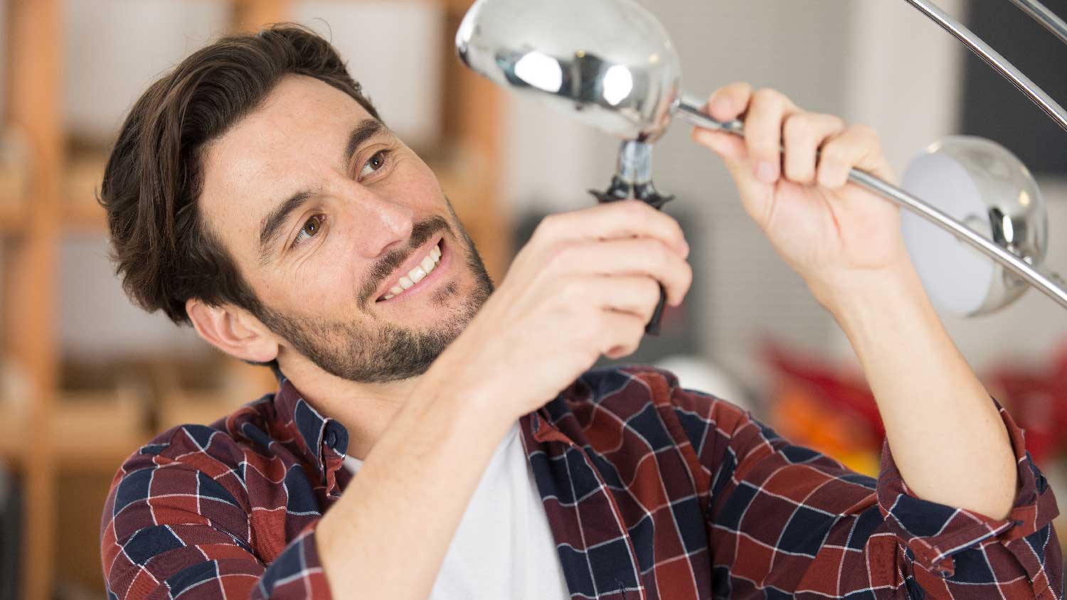 A man removing a light bulb with pliers