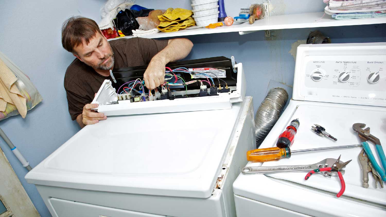 A man repairing a dryer